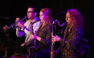 Tre unga musiker spelar tillsammans under en konsert