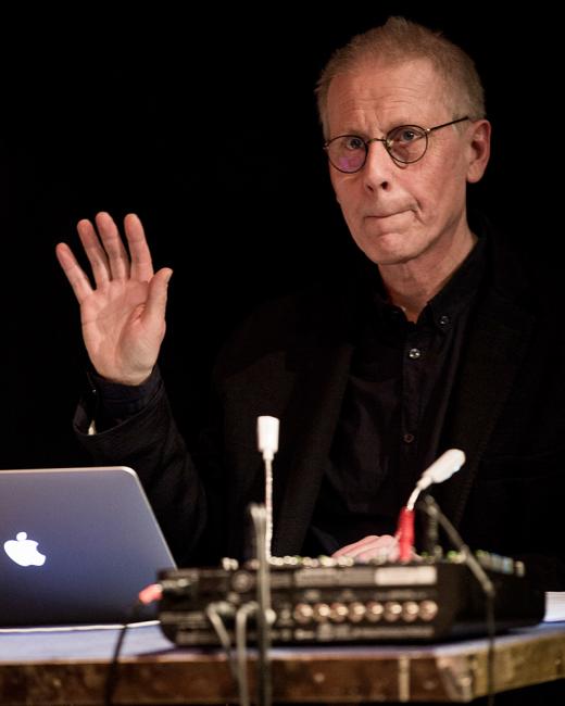 Henrik Strindberg sitter vid en dator och ett mixerbord