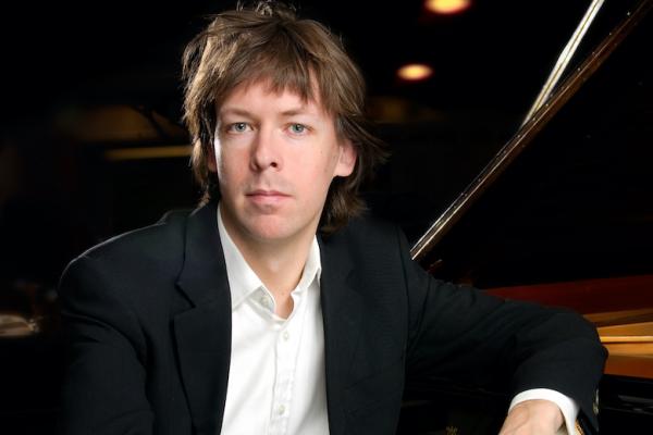 Martin Sturfält lutar sig mot en svart flygel